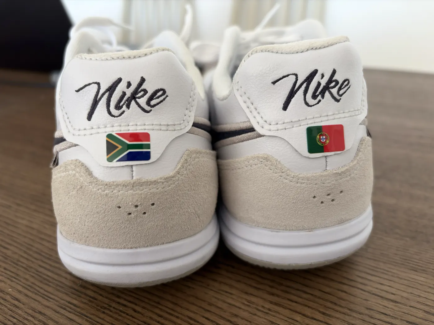Pair of boots from behind with a South Africa flag and a Portugal flag on the heels