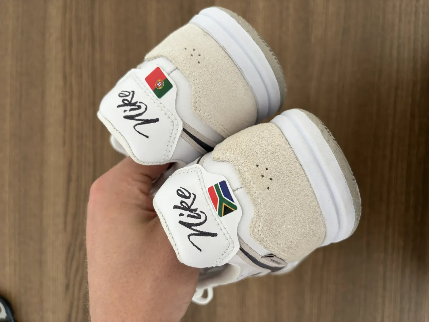 Boots held in hand showing South Africa and Portugal flag transfers on the heels