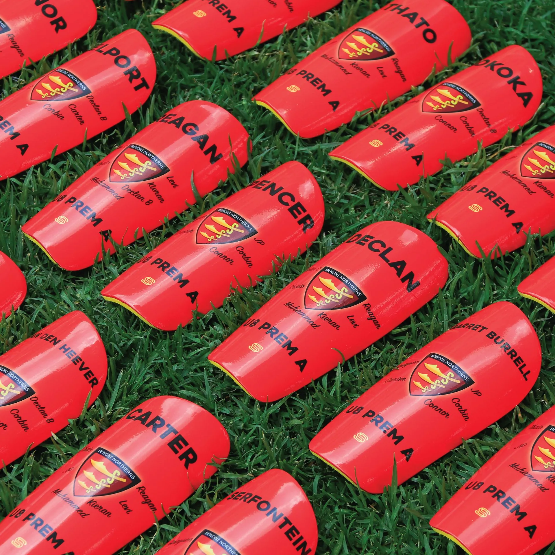 Red club shin pads on grass