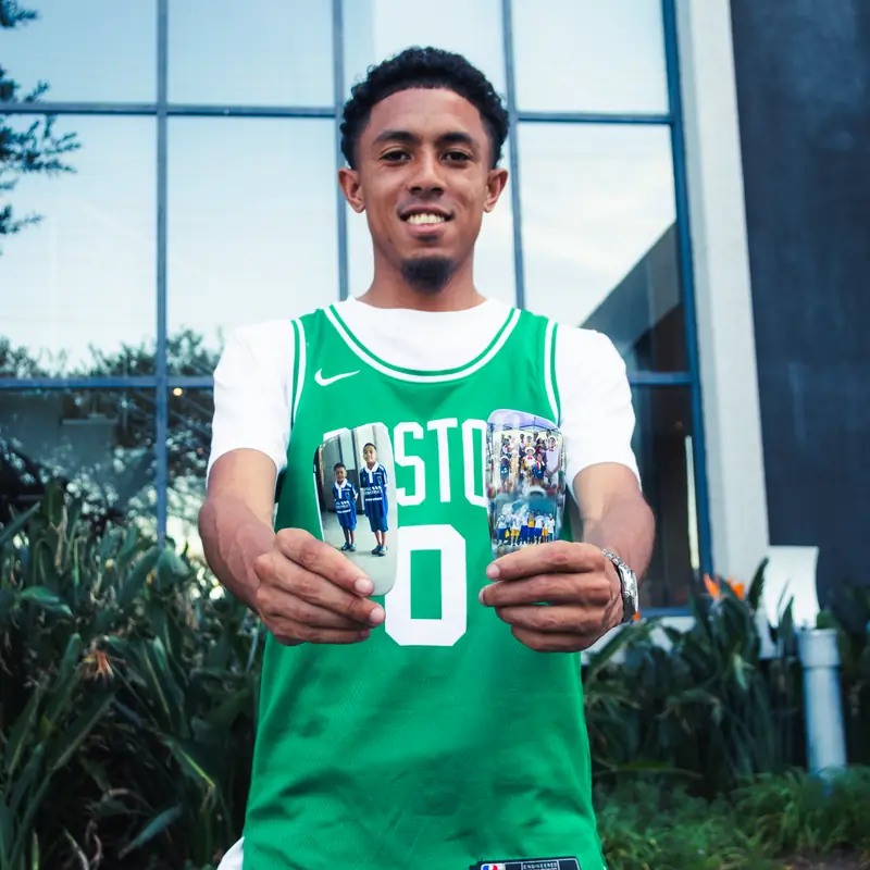 Tashreeq Mathews holding his custom photo shin pads