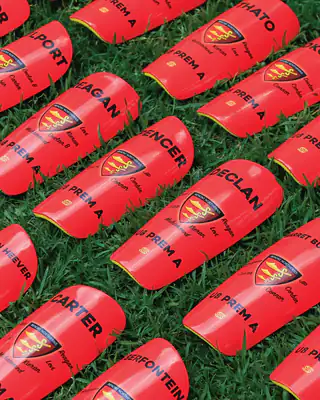 Red club shin pads on grass