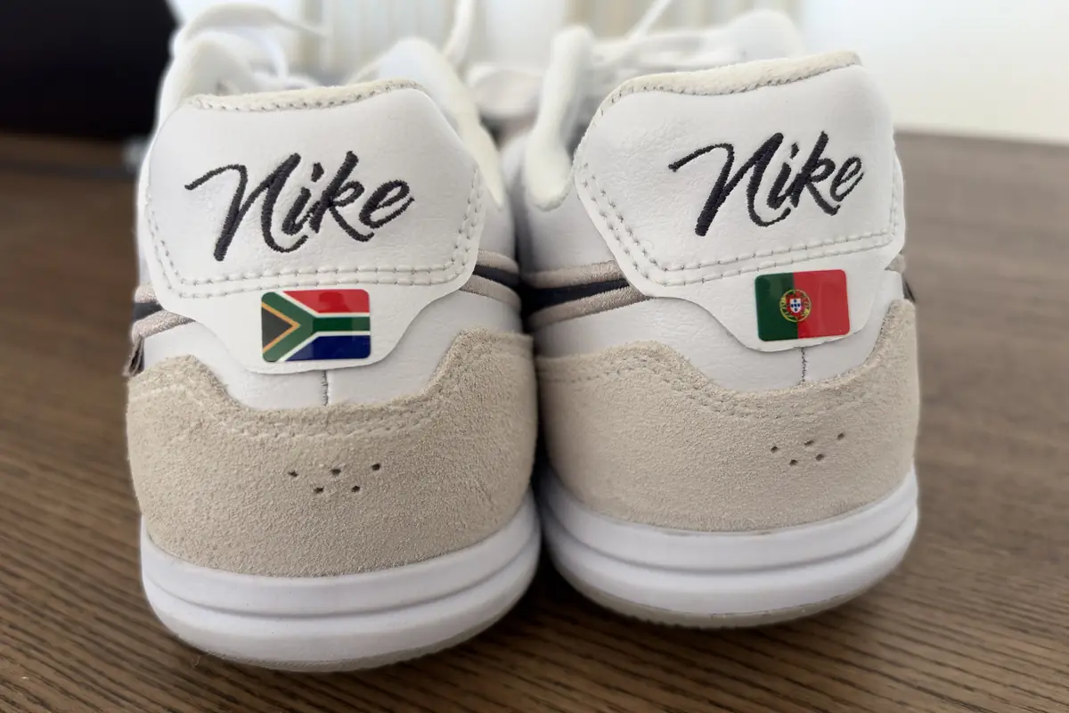 Two white boots with South Africa and Portugal flag Boot ID transfers on the heels