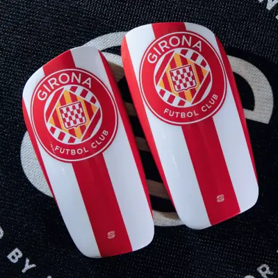 Front of a custom shin pad: glossy printed carbon fibre shell