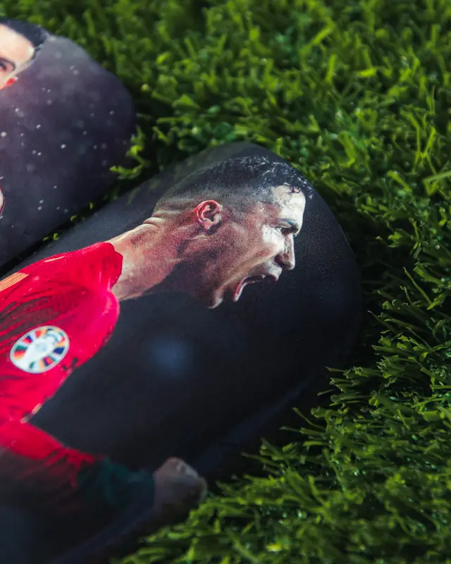 Custom shin pad with a player celebrating in a red kit
