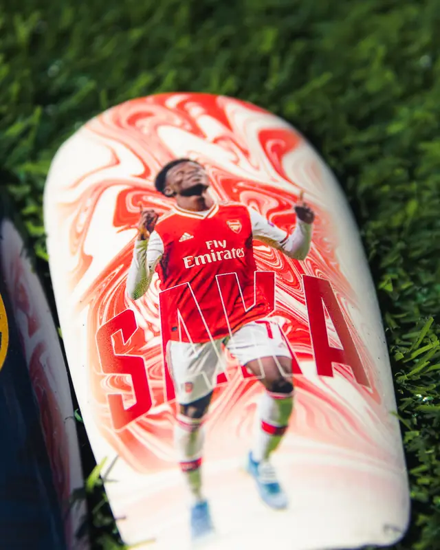 Close-up of a custom shin pad with a red and white marble design